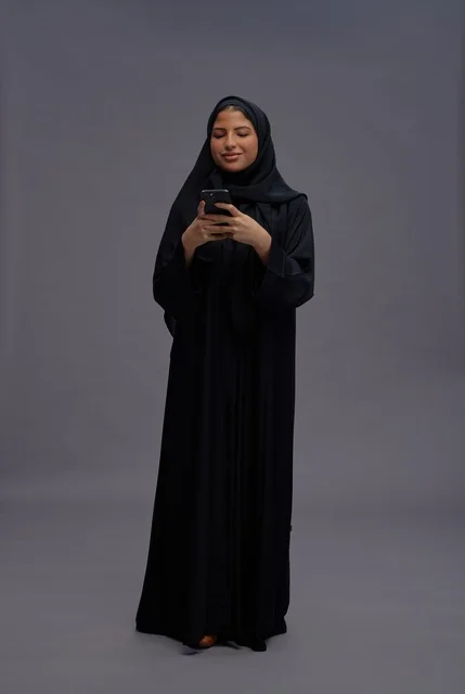 Saudi Woman in Black Abaya Using Smartphone in Studio