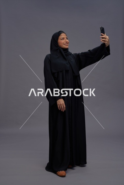 Saudi Woman Taking Selfie with Smartphone in Studio