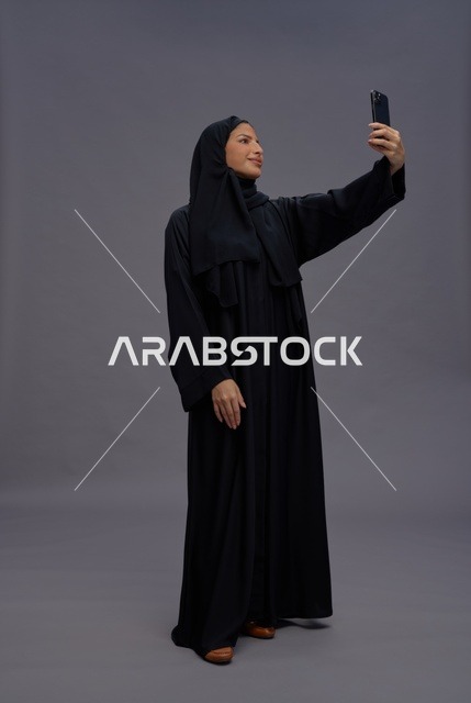 Saudi Woman Taking Selfie with Smartphone in Studio