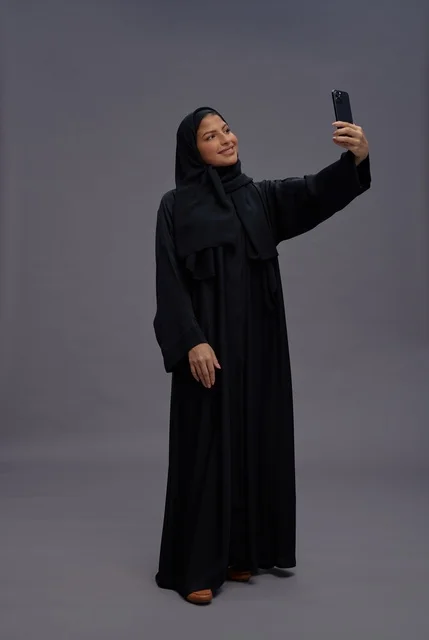 Saudi Woman Taking Selfie with Smartphone in Abaya Saudi Woman Taking Selfie with Smartphone in Abaya