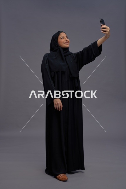 امرأة سعودية تلتقط صورة سيلفي بالعباءة السوداء