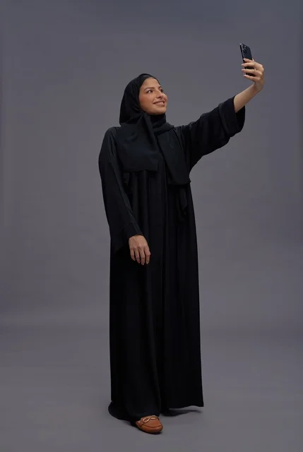 امرأة سعودية تلتقط صورة سيلفي بالعباءة السوداء