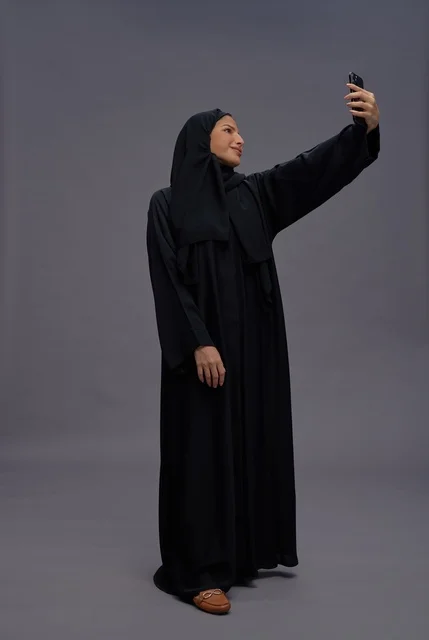 Saudi Woman in Abaya Taking Smartphone Selfie