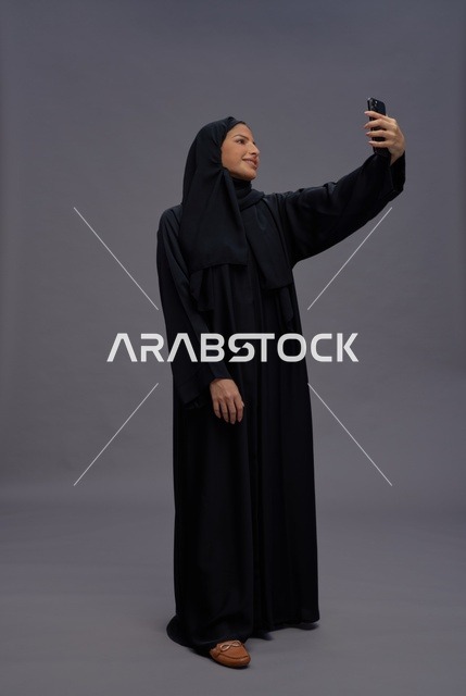 امرأة سعودية تلتقط سيلفي بالهاتف الذكي