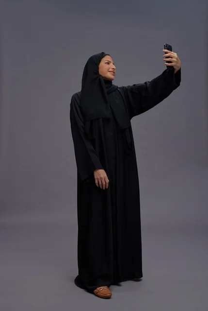 امرأة سعودية تلتقط سيلفي بالهاتف الذكي