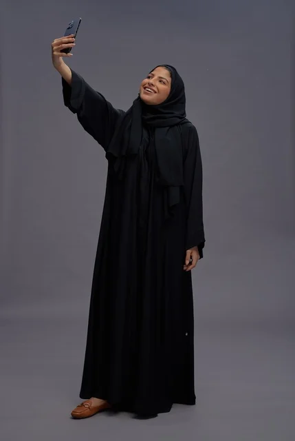 امرأة سعودية تلتقط سيلفي بالعباءة التقليدية