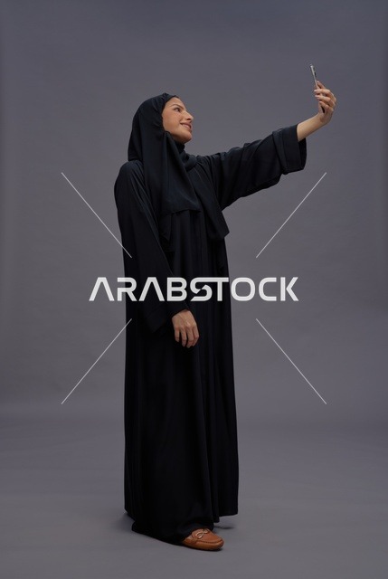 امرأة سعودية تلتقط سيلفي بالهاتف الذكي في الاستوديو