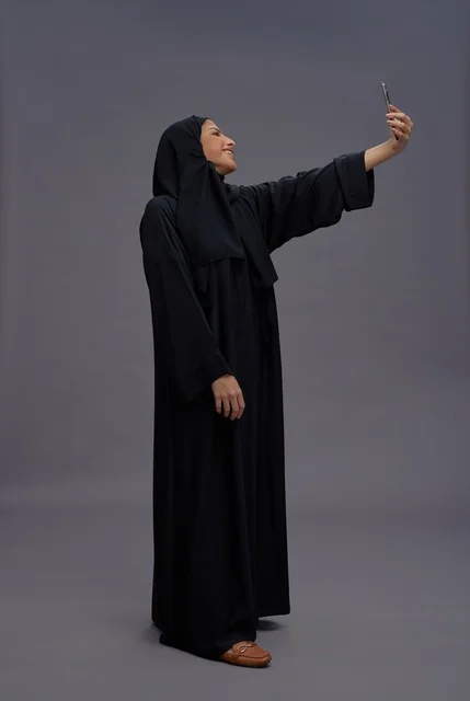 Saudi Woman in Abaya Taking Selfie with Smartphone