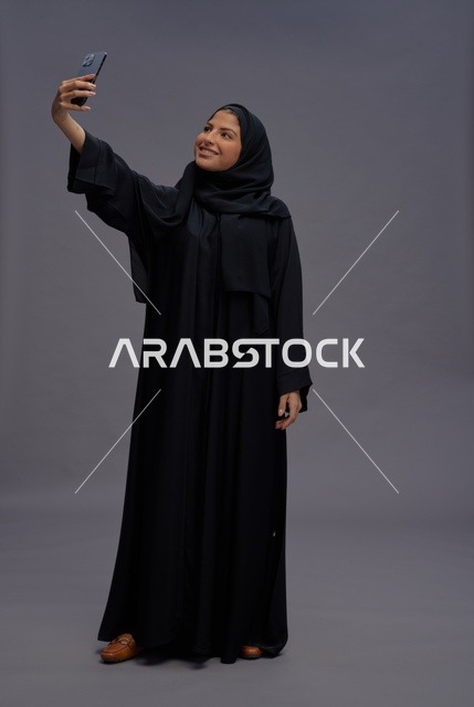 Saudi Woman Taking Selfie with Smartphone in Abaya