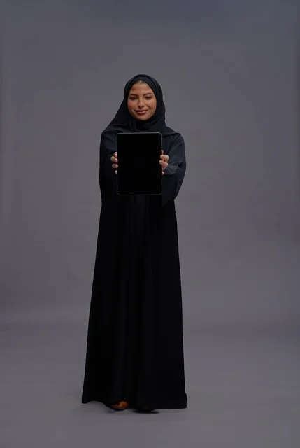 Saudi Woman Holding Tablet with Blank Screen in Studio