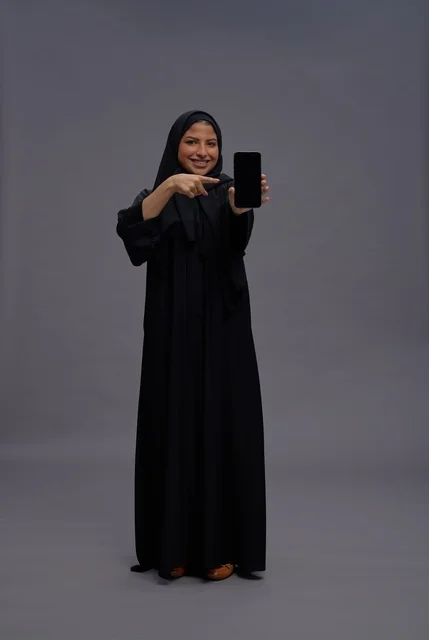Saudi Woman in Abaya Holding Smartphone Screen