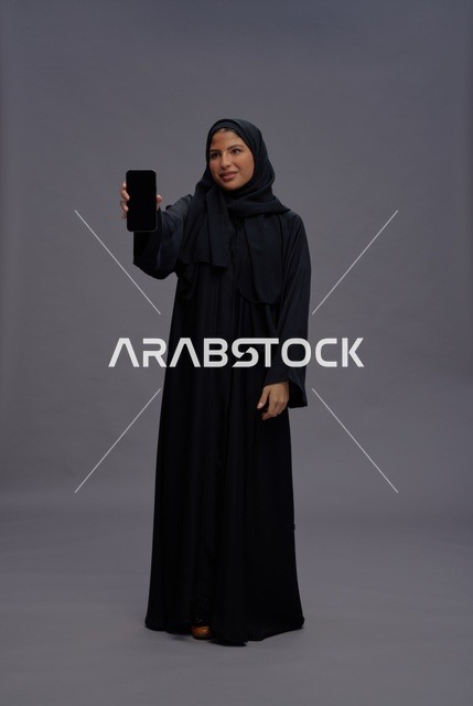 Saudi Woman in Black Abaya Holding Smartphone Screen Mockup