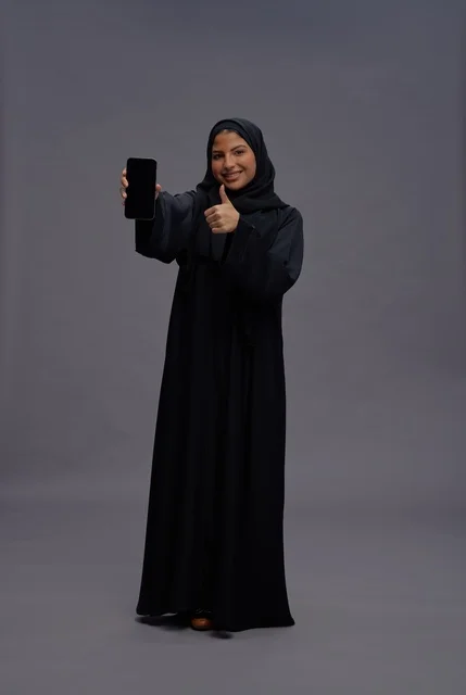 Saudi Woman in Abaya Holding Smartphone Thumbs Up