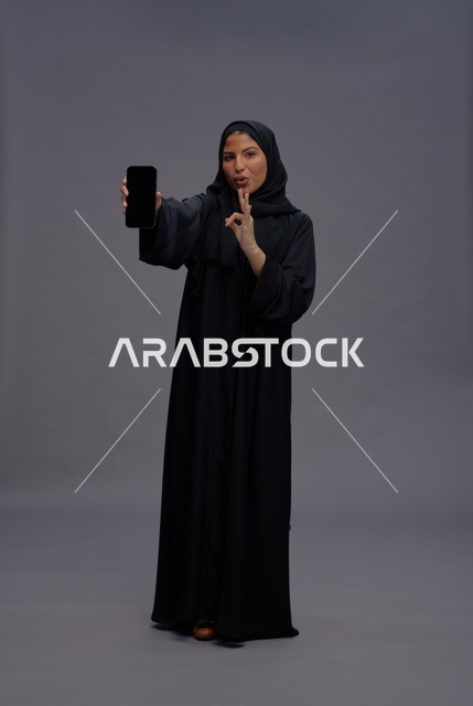 Saudi Woman Holding Blank Smartphone in Studio
