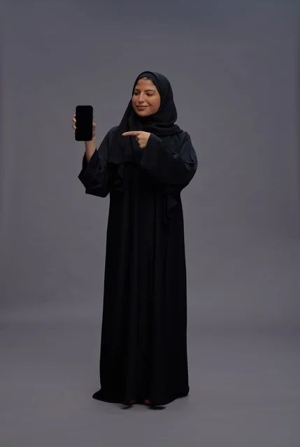 Saudi Woman in Abaya Pointing at Smartphone Screen