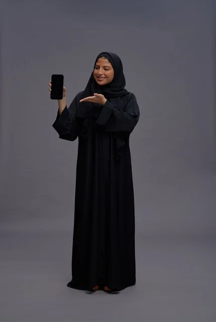 Saudi Woman in Abaya Holding Blank Smartphone Screen