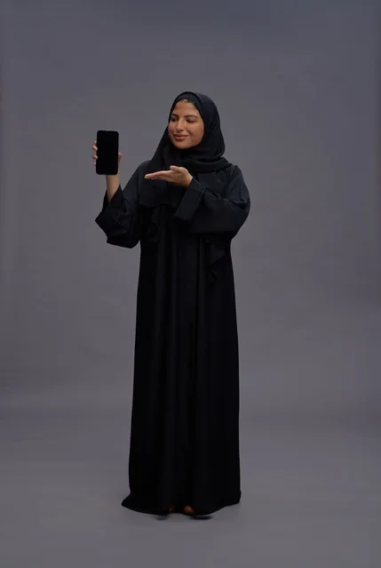 Saudi Woman in Abaya Holding Smartphone with Blank Screen