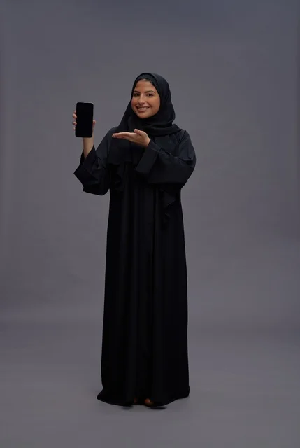 Saudi Woman in Abaya Holding Smartphone Blank Screen