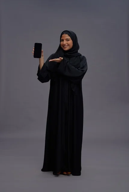 Saudi Woman in Abaya Holding Smartphone with Blank Screen