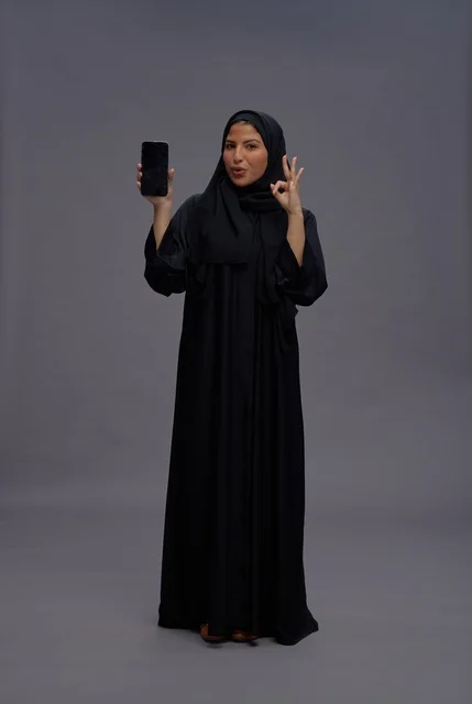 Saudi Woman in Abaya Holding Smartphone Blank Screen