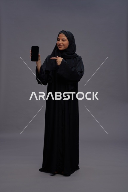 Saudi Woman in Abaya Holding Blank Smartphone Screen