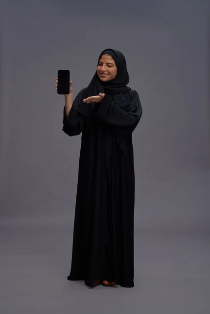 Saudi Woman in Abaya Holding Smartphone Blank Screen