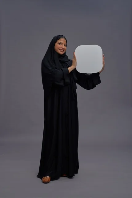 Saudi Woman in Traditional Abaya Holding Blank White Board