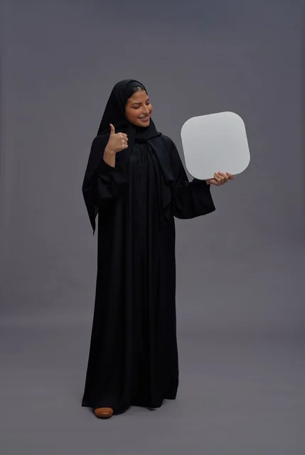 Saudi Woman in Abaya Holding Blank Board Thumbs Up Studio