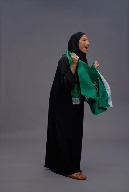 امرأة سعودية تمسك علم المملكة العربية السعودية بهتاف امرأة سعودية تمسك علم المملكة العربية السعودية بهتاف