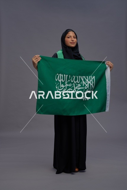 امرأة سعودية تمسك علم المملكة العربية السعودية