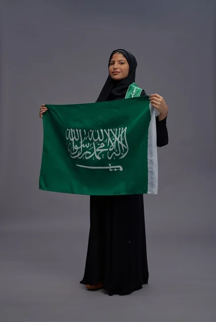 Saudi Woman Holding National Flag on Grey Background