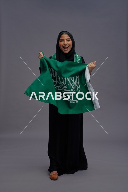 امرأة سعودية تمسك علم المملكة العربية السعودية