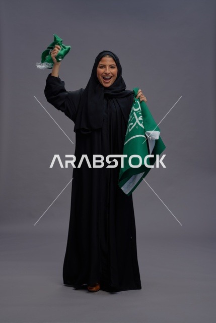 امرأة سعودية تمسك بعلم المملكة في الاستوديو