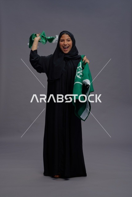 امرأة سعودية تحتفل حاملة علم المملكة العربية السعودية