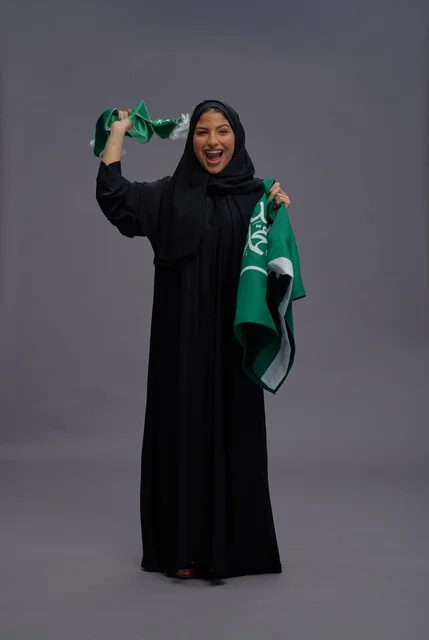 Saudi Woman Holding National Flag in Studio Celebration