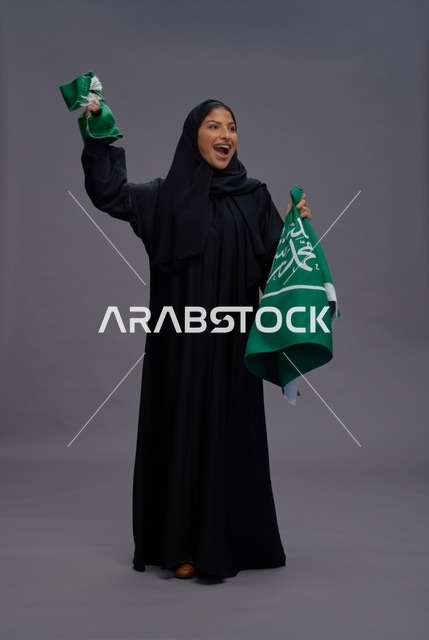 امرأة سعودية تحمل العلم الوطني السعودي احتفالاً