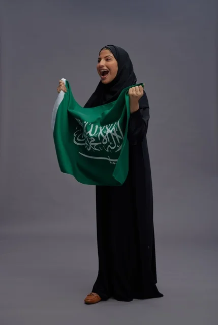 امرأة سعودية تحمل علم المملكة باحتفال وفخر امرأة سعودية تحمل علم المملكة باحتفال وفخر