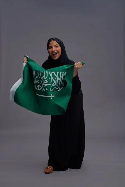 امرأة سعودية تمسك علم المملكة في الاستوديو امرأة سعودية تمسك علم المملكة في الاستوديو