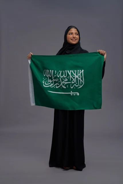 Saudi Woman Holding National Flag on Grey Background