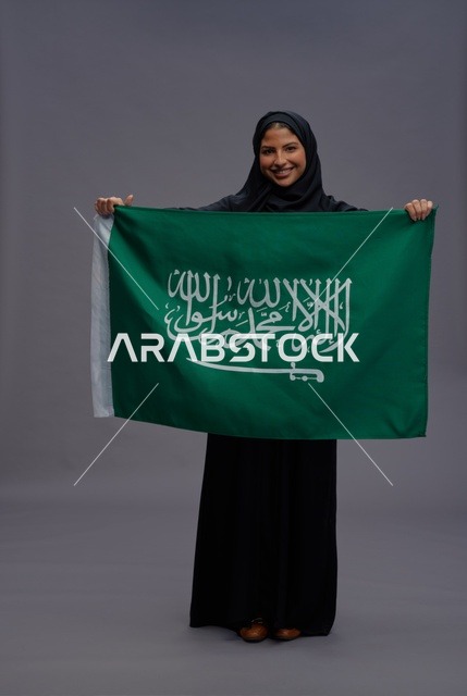 امرأة سعودية تمسك علم المملكة العربية السعودية