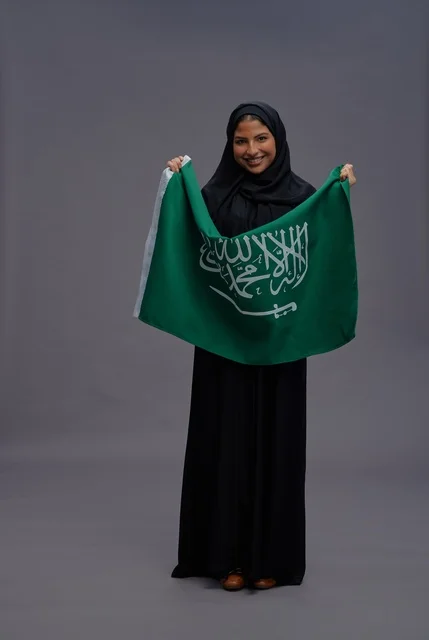 Saudi Woman Holding Saudi Arabia Flag in Studio