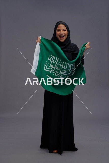 امرأة سعودية تحمل علم المملكة العربية السعودية