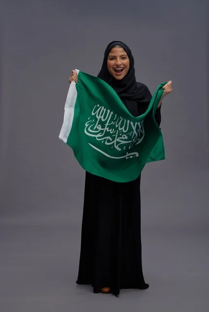 امرأة سعودية تحمل علم المملكة العربية السعودية