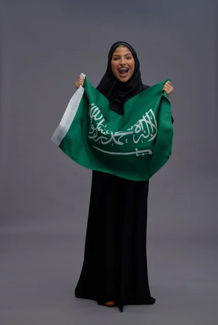 امرأة سعودية تمسك علم المملكة العربية السعودية