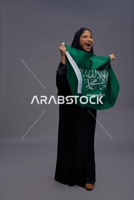امرأة سعودية تحمل علم المملكة العربية السعودية