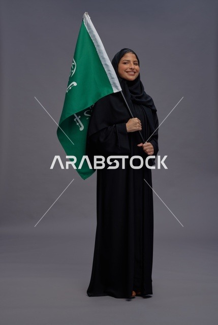 امرأة سعودية تحمل علم المملكة العربية السعودية