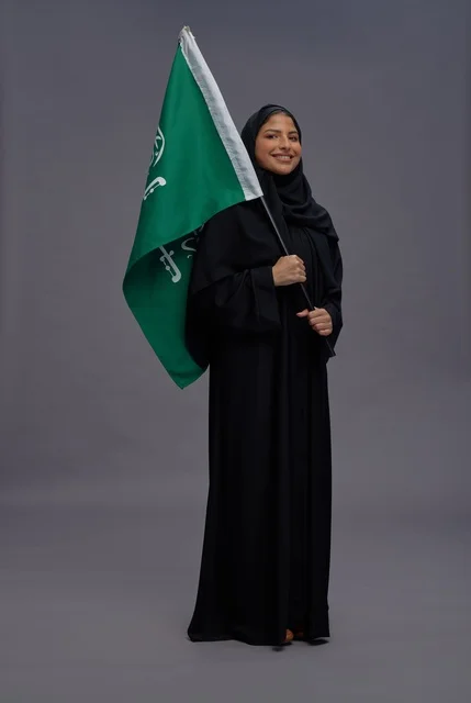 امرأة سعودية تحمل علم المملكة العربية السعودية