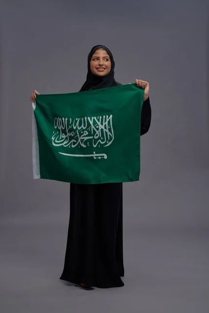 امرأة سعودية تحمل علم المملكة في الاستوديو امرأة سعودية تحمل علم المملكة في الاستوديو