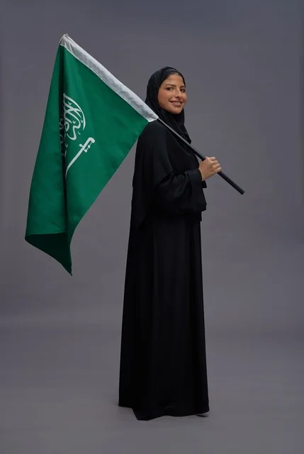 امرأة سعودية تحمل علم المملكة في الاستوديو امرأة سعودية تحمل علم المملكة في الاستوديو
