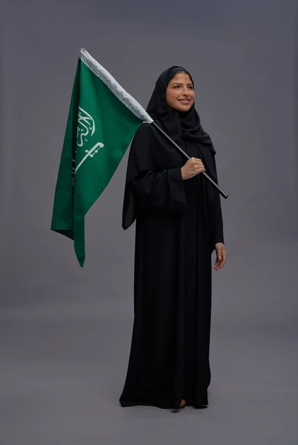 امرأة سعودية تحمل علم المملكة في الاستوديو